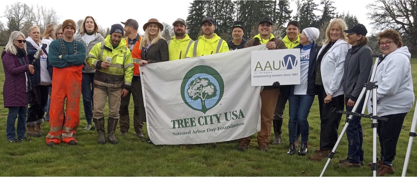 Group holding a banner with Tree City USA and an AAUW Sign.